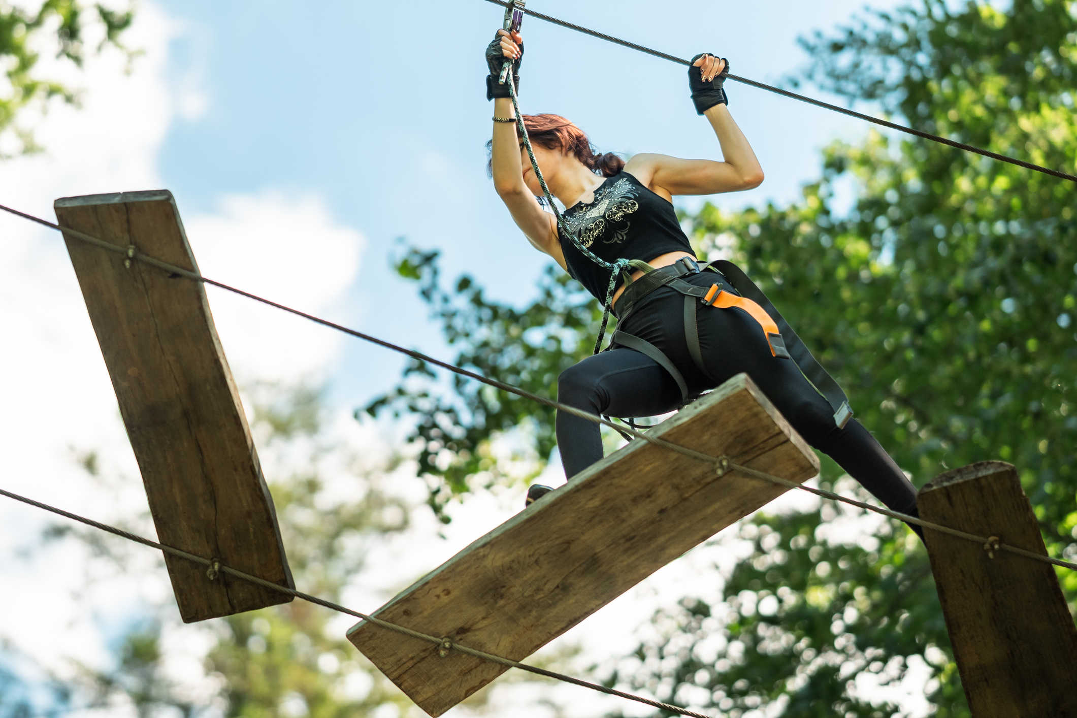 Woman navigating floating boards on adventure course