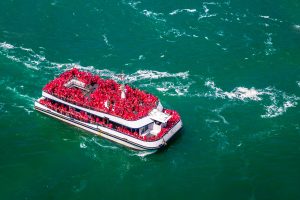 Tourists enjoying the Hornblower boat ride during a Niagara Falls celebration tour